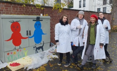 Sch&uuml;ler*innen bemalen einen Stromkasten.